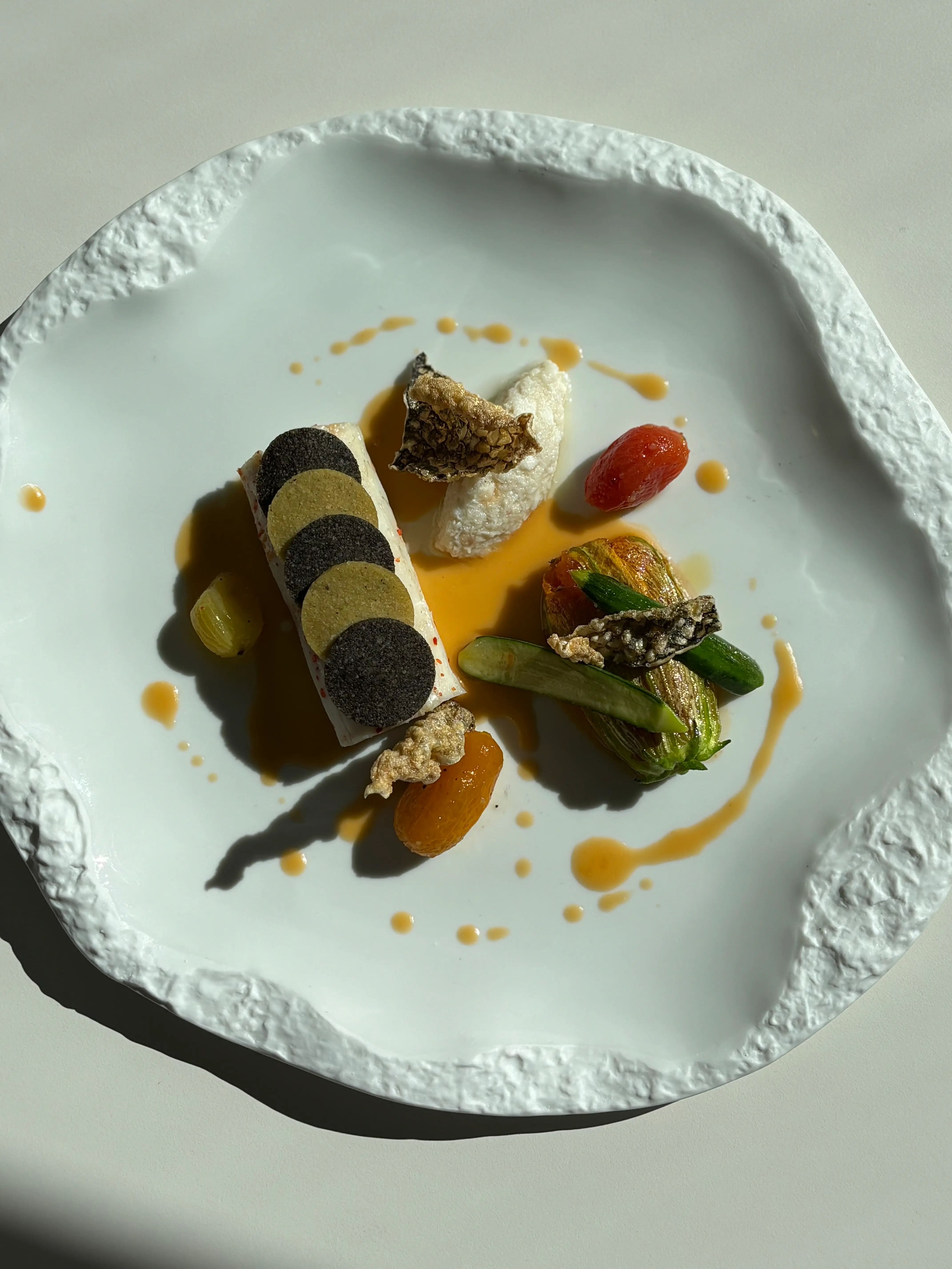 Confit seabass / olive crust / white tomato sauce / zucchini flower